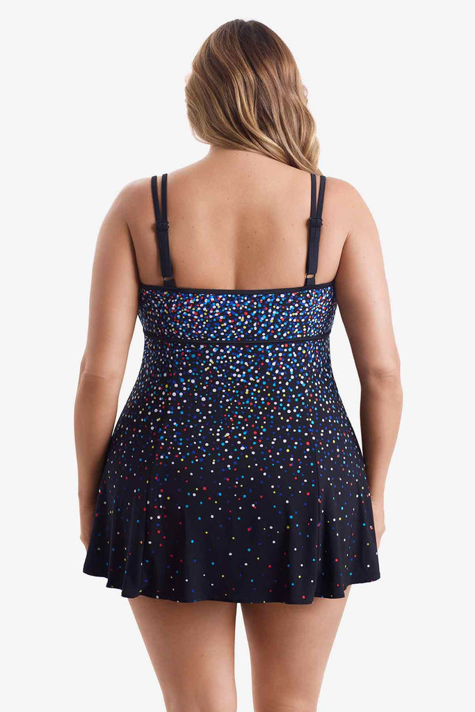 Woman turned away wearing a swim dress with a multicolored dot pattern