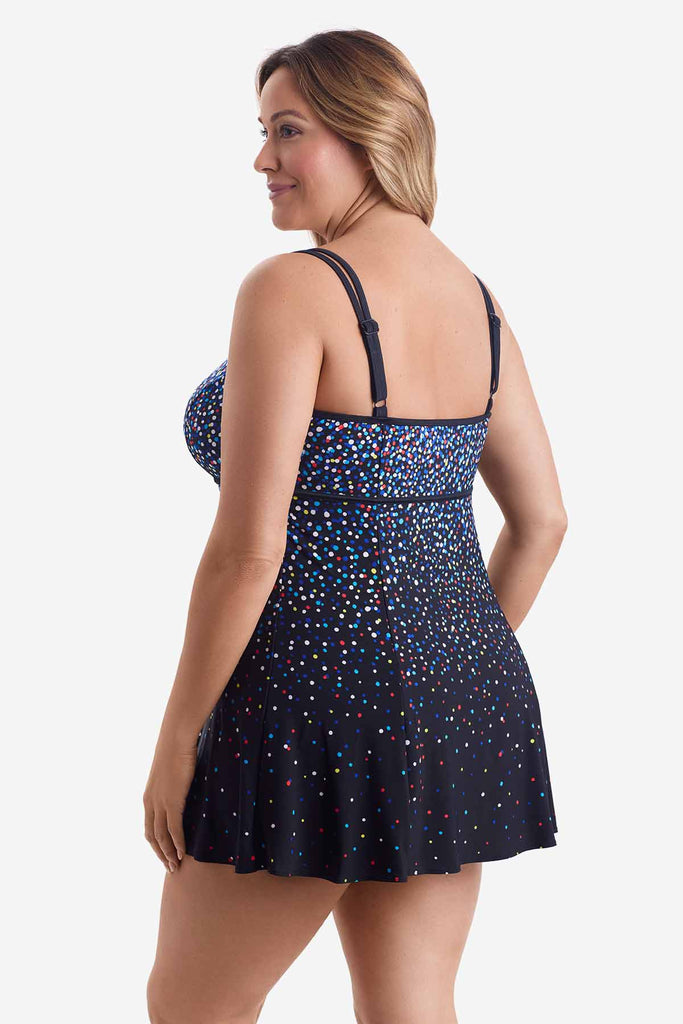 Woman turned left wearing a swim dress with a multicolored dot pattern