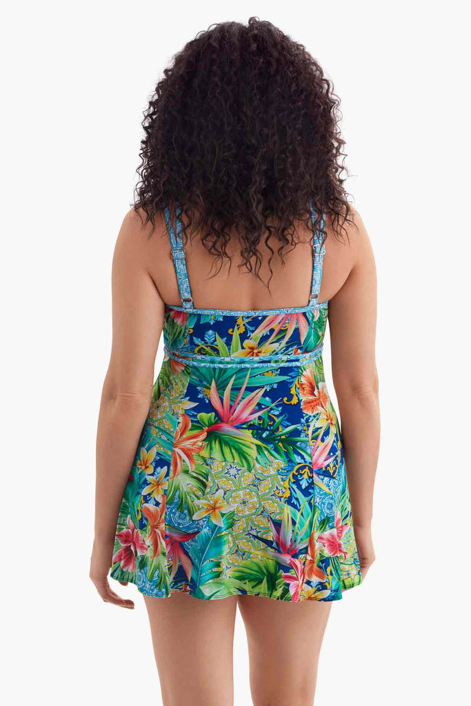 Woman turned away wearing a multicolored swim dress with a palm leaf pattern