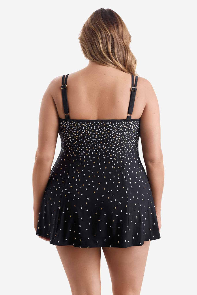 Woman turned away wearing a swim dress with a white and gold sprinkle pattern