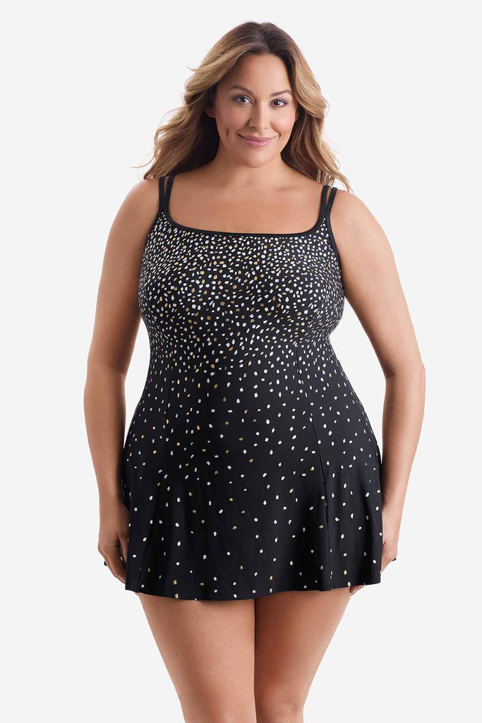 Woman wearing a swim dress with a white and gold sprinkle pattern