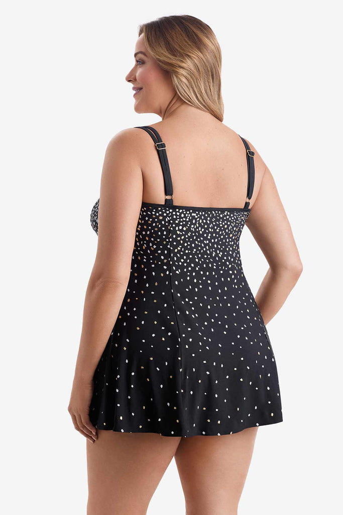 Woman turned left wearing a swim dress with a white and gold sprinkle pattern