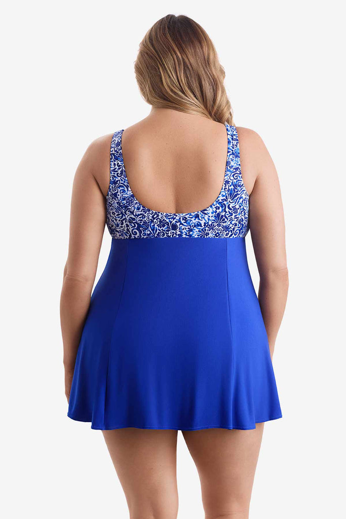 Woman turned away wearing a blue swim dress with an abstract pattern on the bust