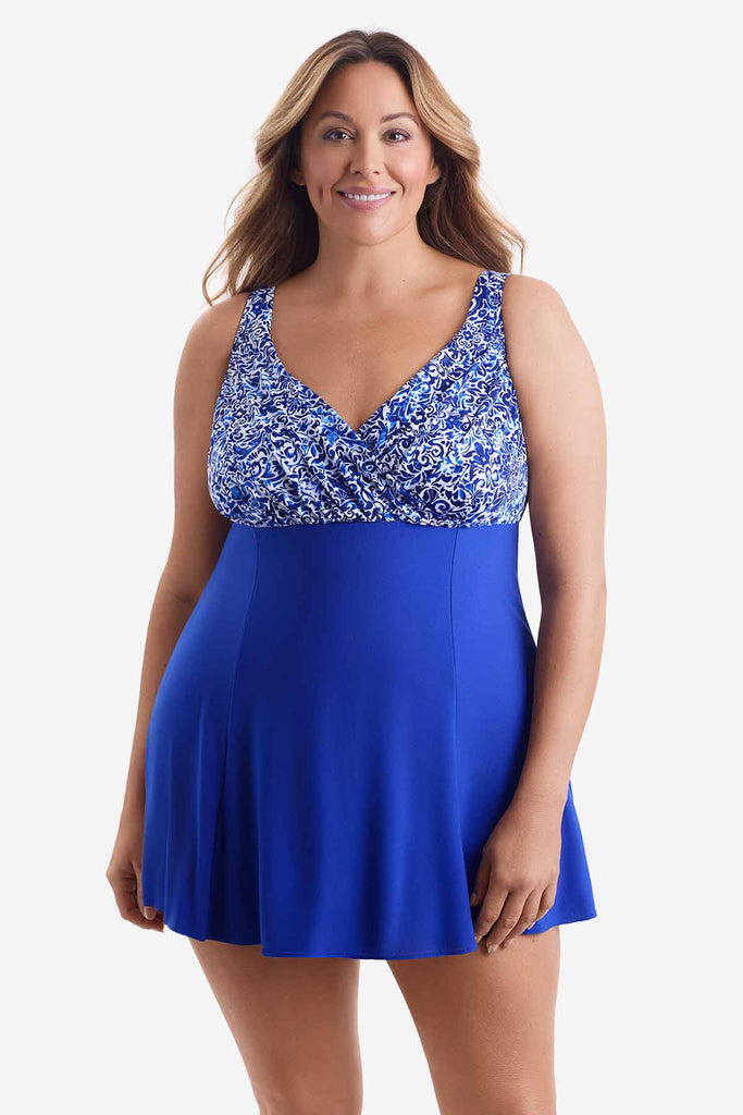 Woman wearing a blue swim dress with an abstract pattern on the bust