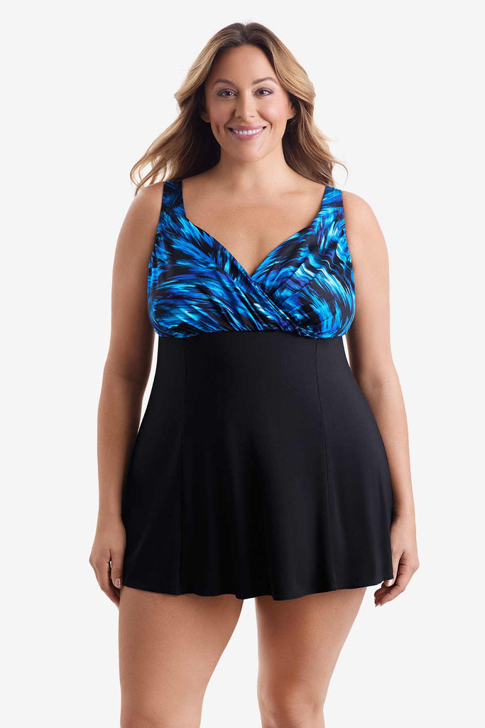 Woman wearing a swim dress with a black and blue print on the bust