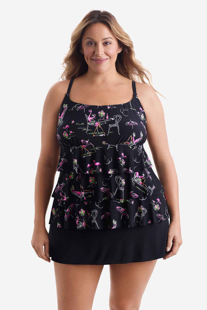 Woman wearing a black tiered one-piece swimsuit with a flamingo print