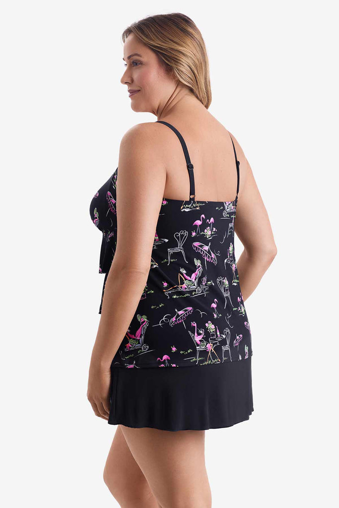 Woman turned left wearing a black tiered one-piece swimsuit with a flamingo print