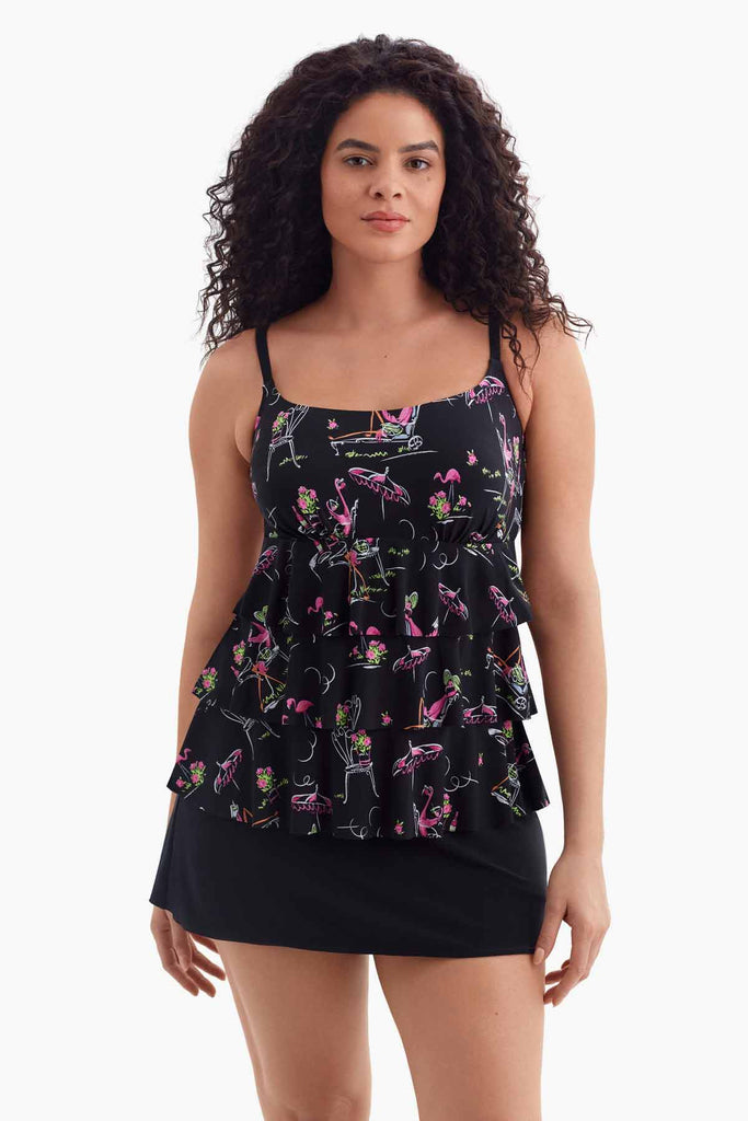 Woman wearing a black tiered swim dress with a flamingo pattern