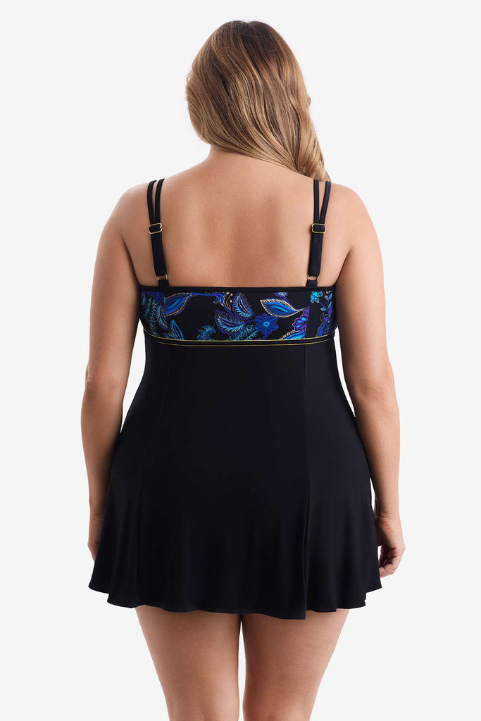 Woman turned away wearing a swim dress with a blue floral print on the bust