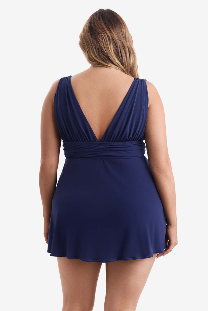 Woman turned away wearing a navy blue swim dress with a V neckline