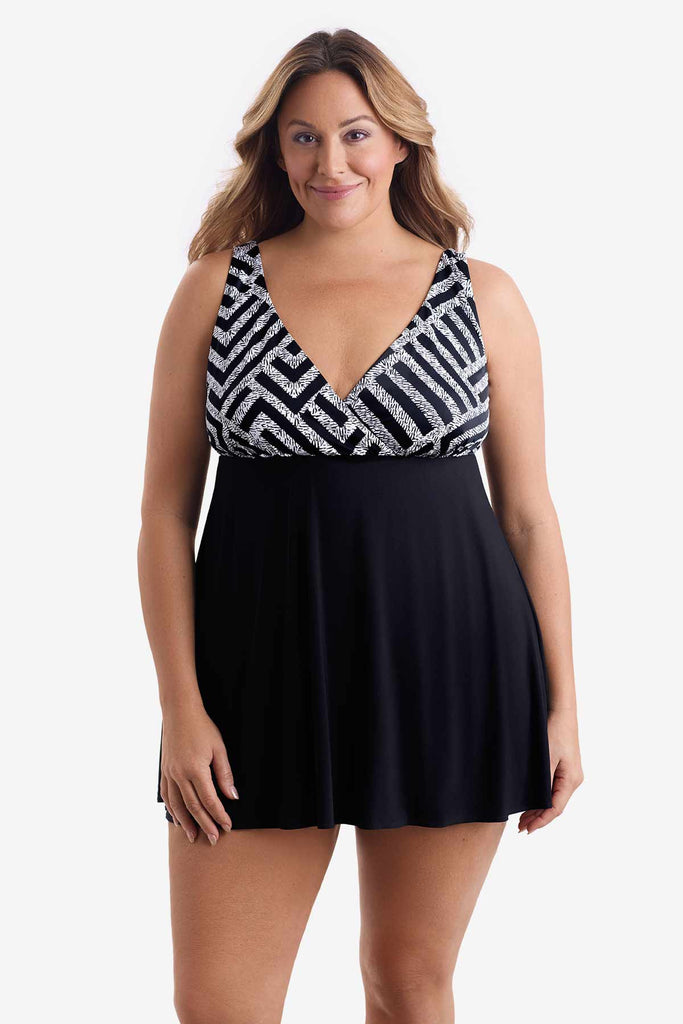 Woman wearing a one-piece swim dress with a black and white pattern on the bust