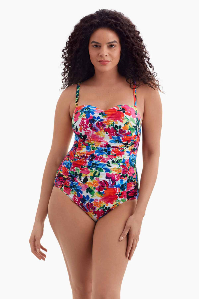 Woman wearing a one-piece swimsuit with a multicolored floral print