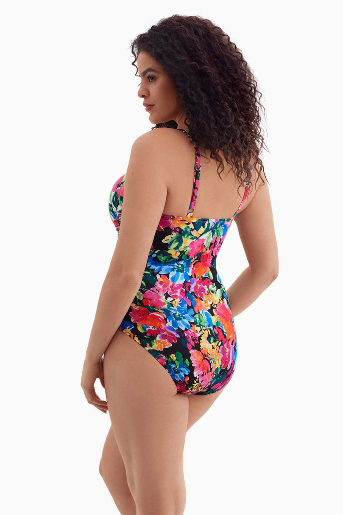 Woman turned left wearing a one-piece swimsuit with a multicolored floral print