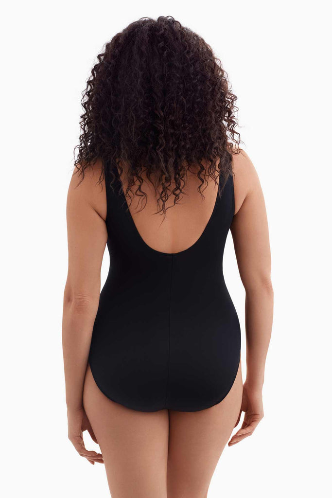 Woman turned away wearing a wrap-sash one-piece swimsuit 