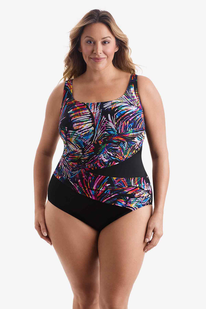 Woman wearing a wrap-sash one-piece swimsuit with a multicolored pattern