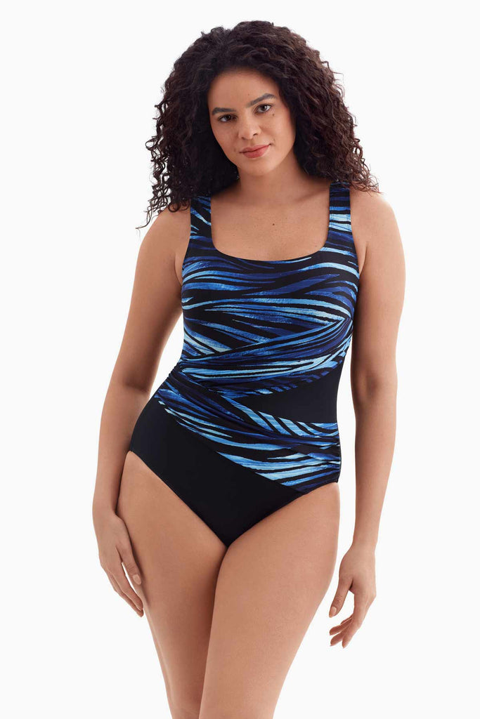 Woman wearing a black and blue printed one-piece swimsuit