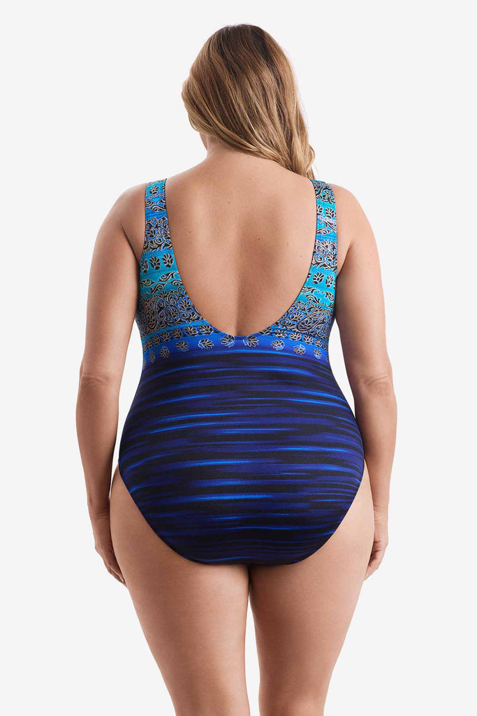 Woman faced away wearing a one-piece swimsuit with a dual pattern in blue