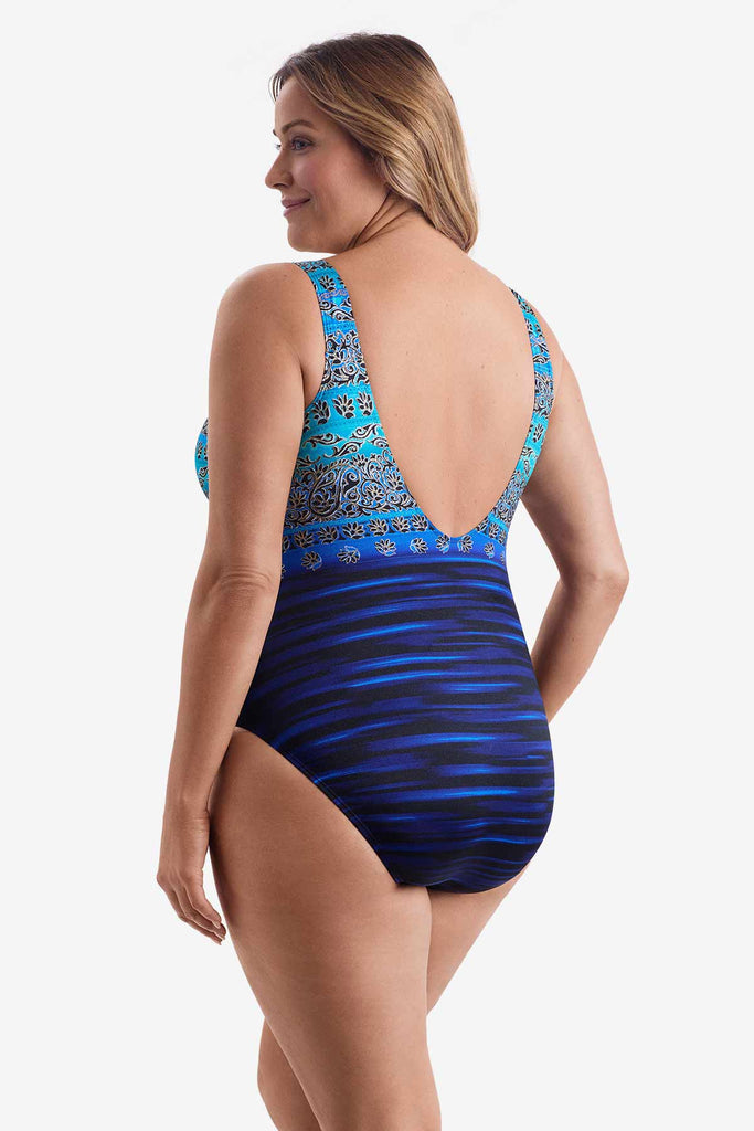 Woman turned left wearing a one-piece swimsuit with a dual pattern in blue