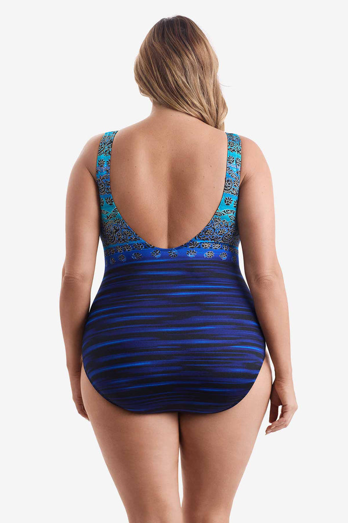 Woman turned away wearing a one-piece swimsuit with a multi pattern blue print