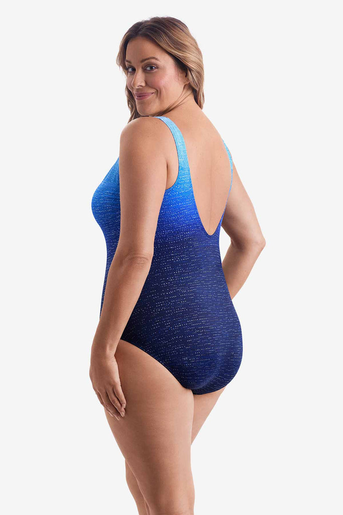 Woman faced left wearing a one-piece swimsuit with a blue ombre pattern