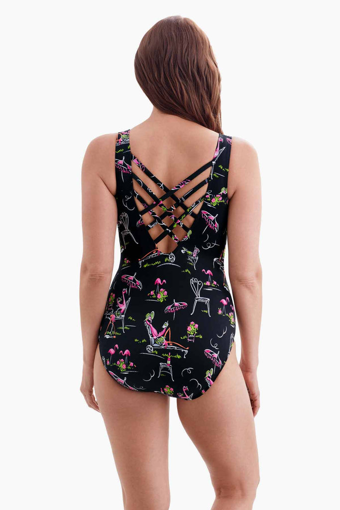 Woman faced away wearing a black one-piece swimsuit with a flamingo print with an X back detail