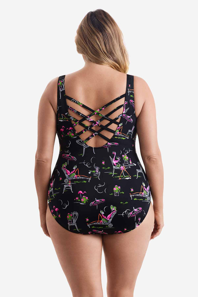 Woman faced away wearing a one-piece swimsuit with a flamingo pattern