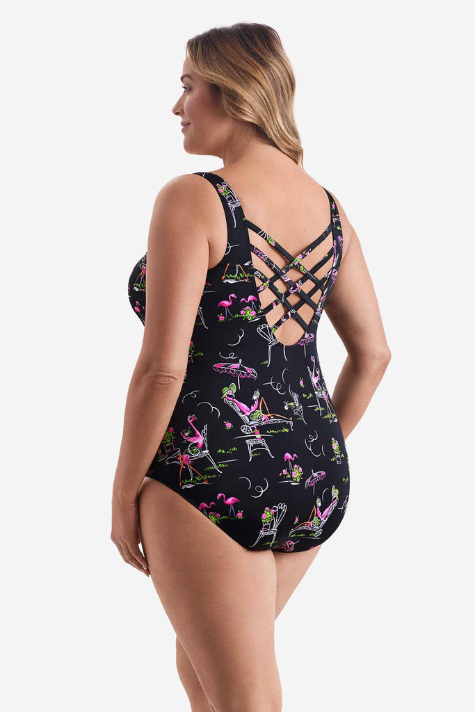 Woman faced left wearing a one-piece swimsuit with a flamingo pattern