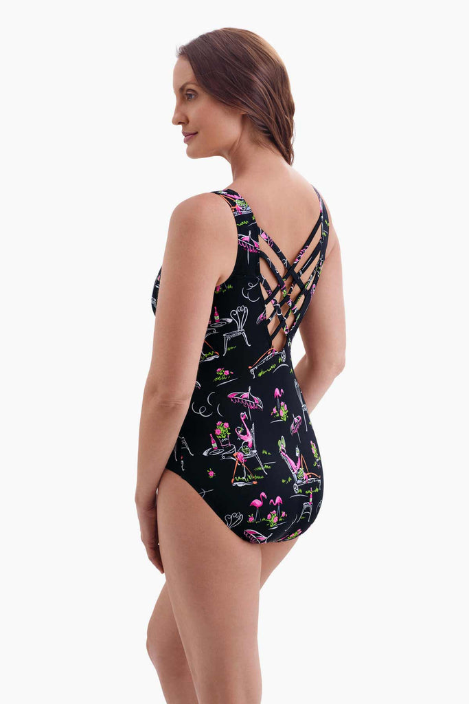 Woman faced left wearing a black one-piece swimsuit with a flamingo print