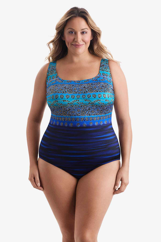 Woman wearing a one-piece swimsuit with various blue patterns throughout suit