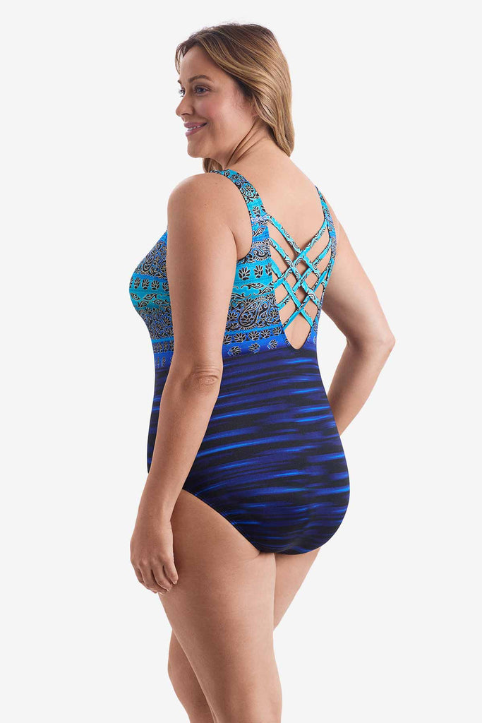 Woman looked left wearing a one-piece swimsuit with various blue patterns throughout suit