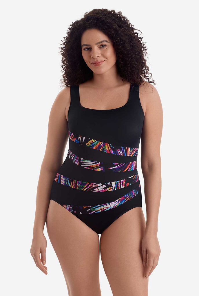 Woman wearing a one-piece swimsuit with multicolored streaks across the body