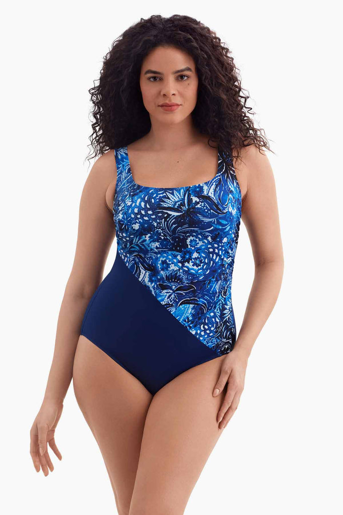 Woman wearing a one-piece swimsuit with a navy blue abstract pattern