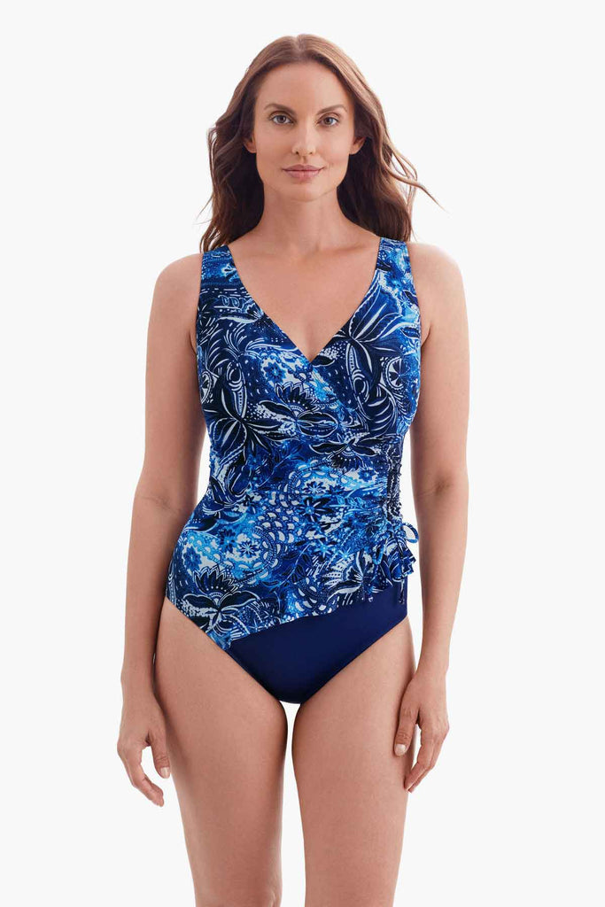 Woman wearing a blue abstract print one-piece swimsuit