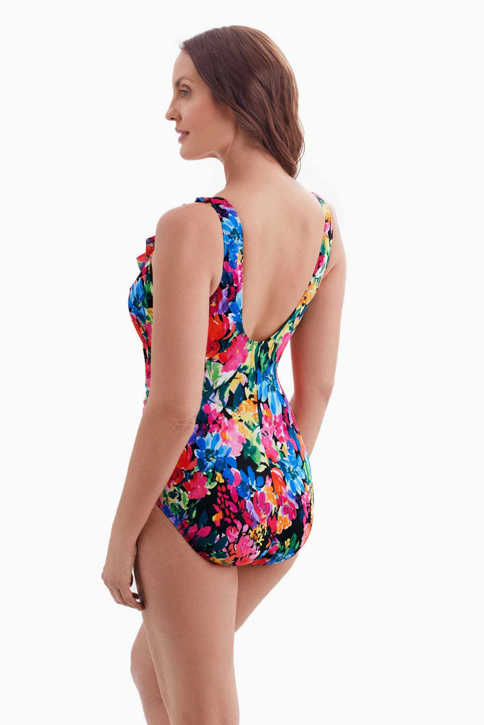 Woman turned left wearing a multicolored floral patterned one-piece swimsuit 