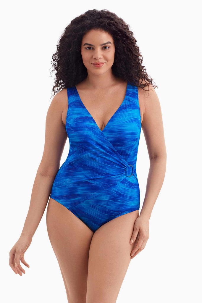 Woman wearing a blue feathered print one-piece swimsuit with an O ring on the side