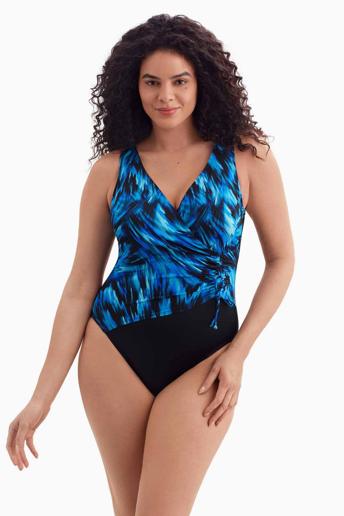 Woman wearing a one-piece swimsuit with a black and blue pattern