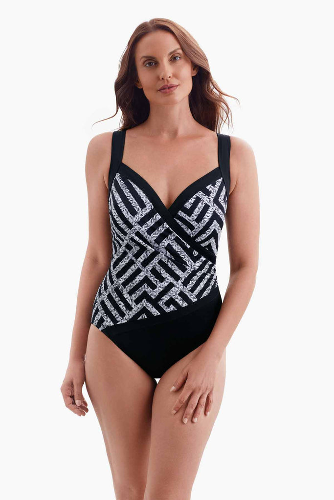 Woman wearing a one-piece sweetheart neckline swimsuit with a black and white pattern