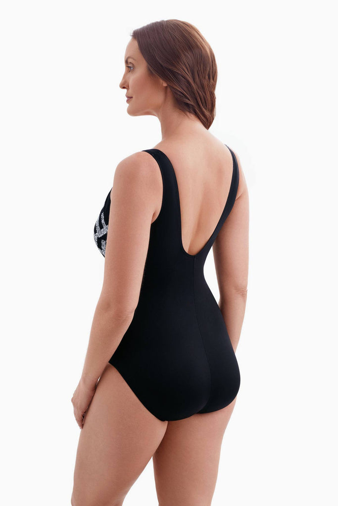 Woman turned left wearing a one-piece swimsuit with a black and white pattern