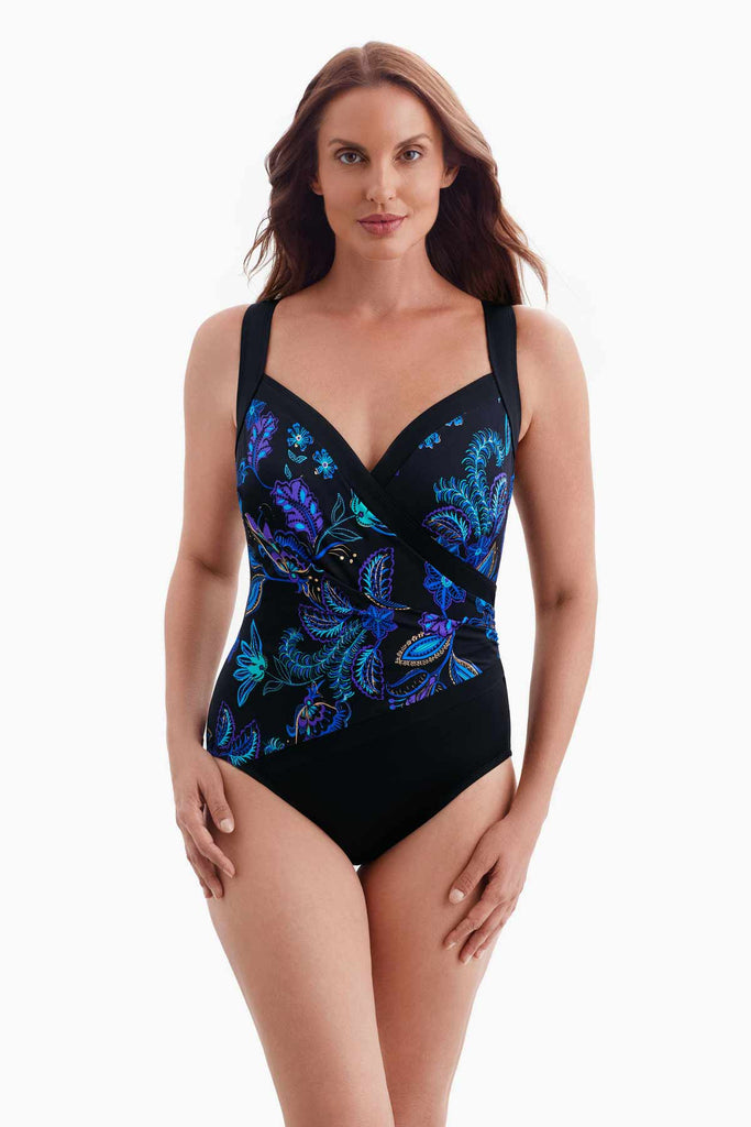 Woman wearing a one-piece sweetheart neckline swimsuit with a blue floral pattern