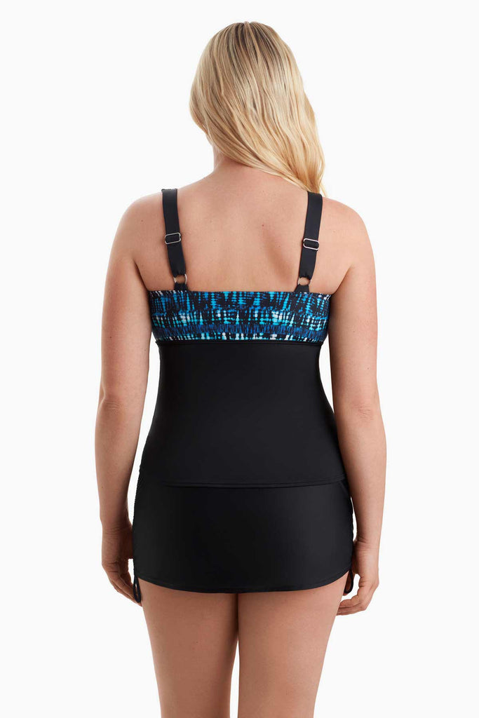 Woman faced away wearing a tankini top with a blue pattern along the back