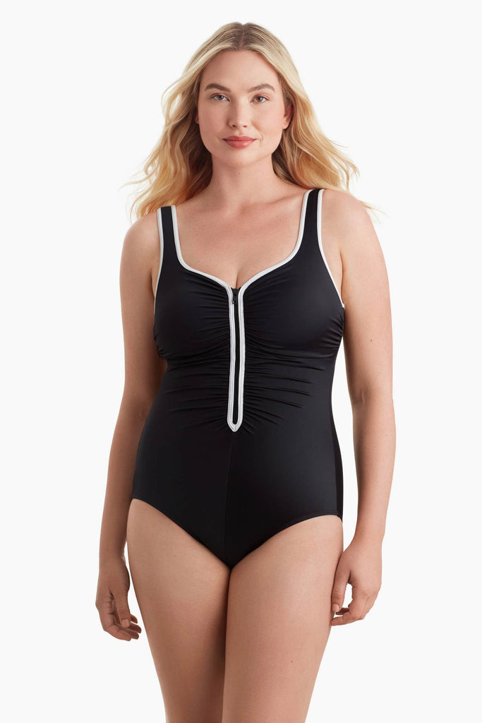 Woman wearing a one-piece swimsuit with white trim on the front