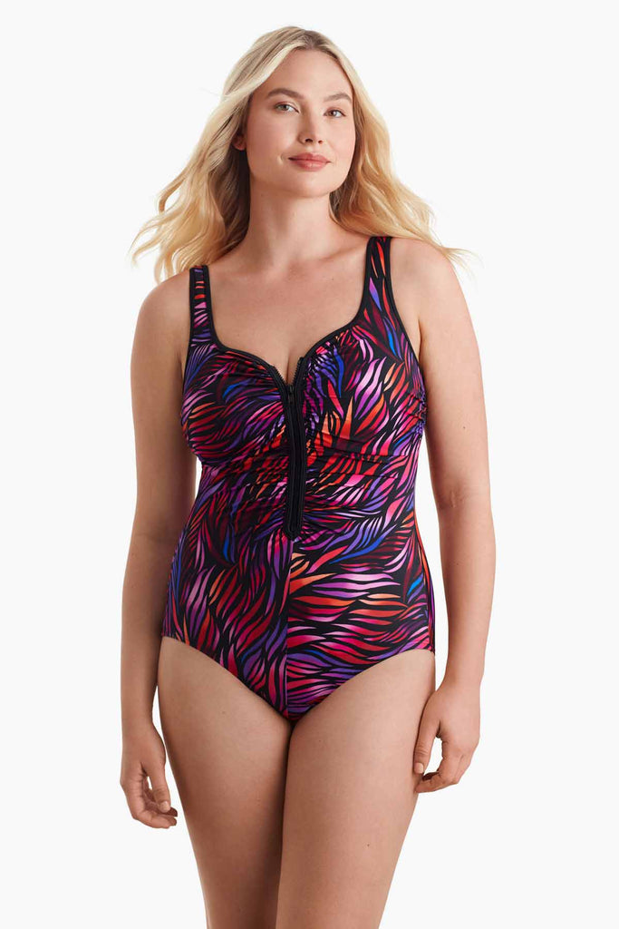 Woman facing forward wearing a multicolored one-piece swimsuit with a zipper detail