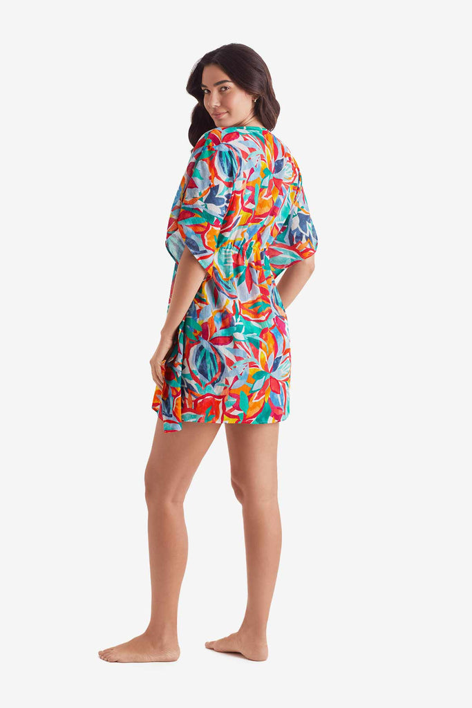 Woman turned left wearing a multicolored floral caftan swim dress cover up