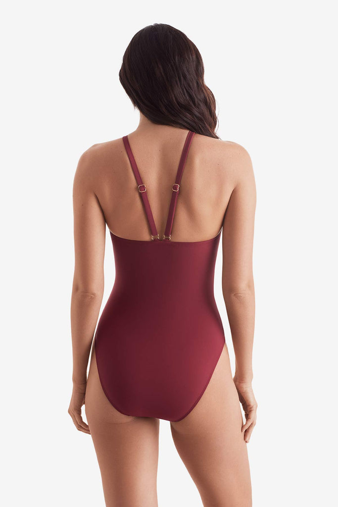 Woman turned away wearing a dark red one-piece swimsuit