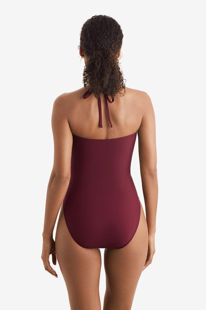 Woman faced away wearing a dark red one-piece swimsuit