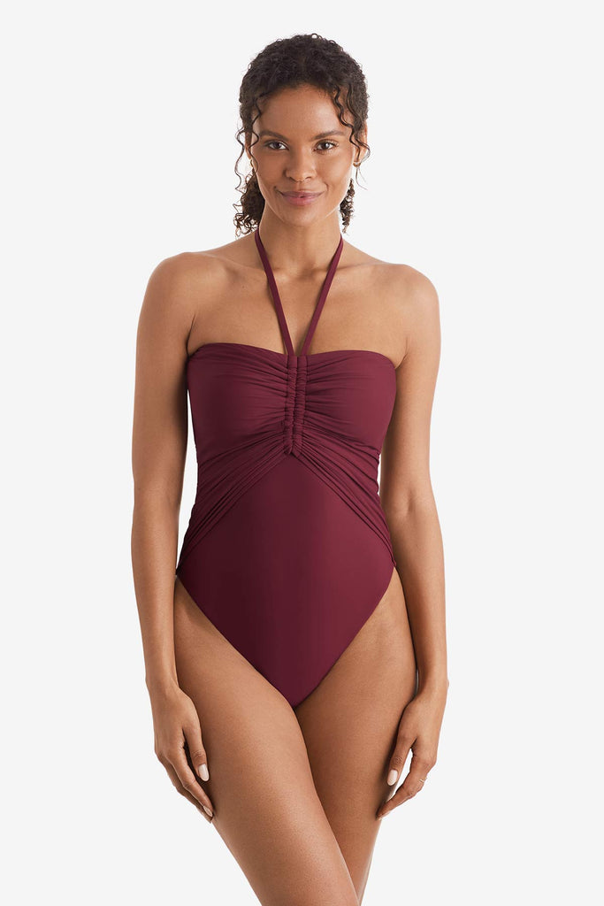 Woman wearing a dark red one-piece swimsuit