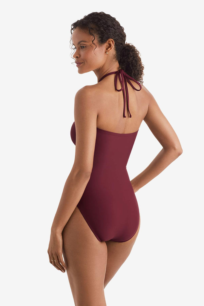 Woman turned left wearing a dark red one-piece swimsuit