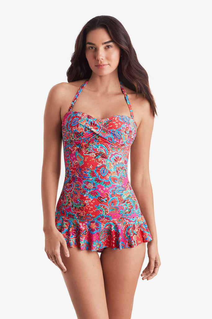 Woman wearing a multicolored bandeau and skirted leg one-piece swimsuit