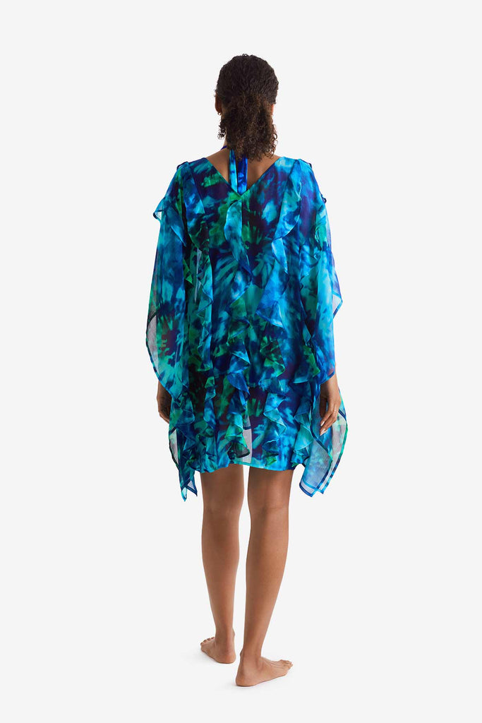 Woman faced away wearing a blue and green tie dye swim poncho cover up 