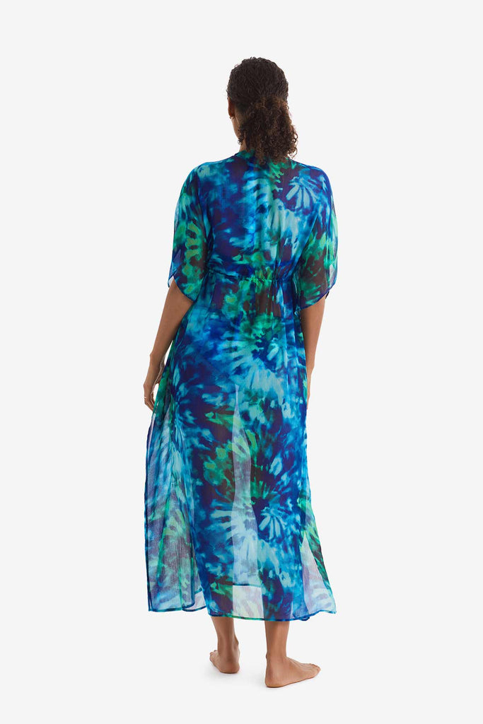 Woman faced away wearing a blue and green tie dye caftan swim dress cover up